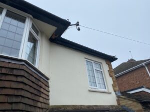 Old and worn-out fascia, soffit, and guttering on a house in Epping, Essex, prior to replacement.