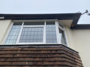 Old and worn-out fascia, soffit, and guttering on a house in Epping, Essex, prior to replacement.