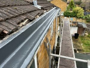 Close-up of concrete gutter sealed with grey resin top coat, providing a smooth and waterproof surface.