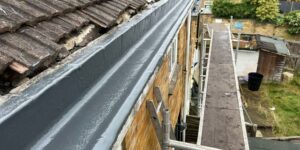 Close-up of concrete gutter sealed with grey resin top coat, providing a smooth and waterproof surface.
