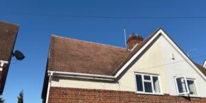 Clean roof under blue sky after moss removal and valley repair in Old Harlow.