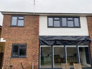 Rear elevation before replacement fascia, soffit, guttering and cladding at a property in Ware