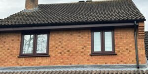 New rosewood effect uPVC fascia, soffit and black guttering installed on a property in Bishop's Stortford